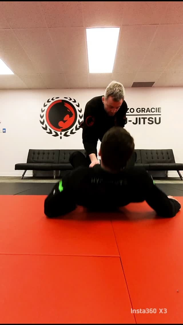 Une ceinture noire travaille du dessus contre un partenaire qui tient la garde
