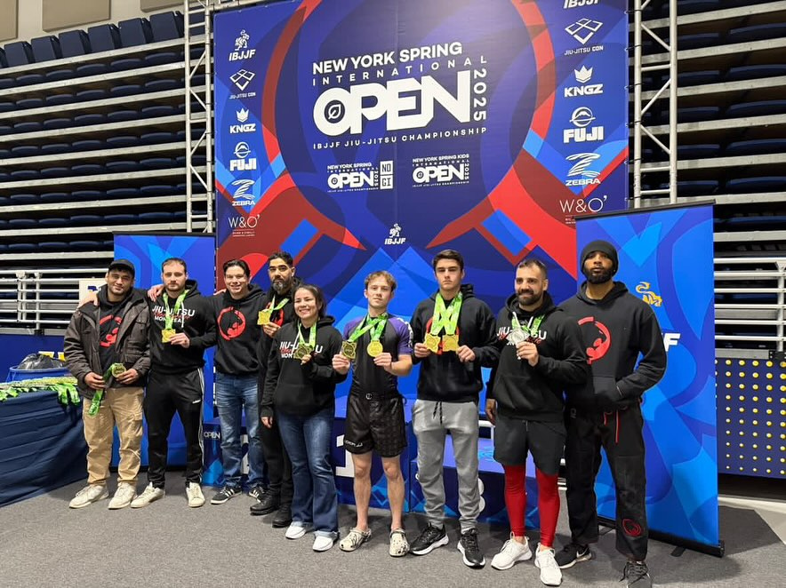 Une équipe en kangourous montre ses médailles devant une bannière de tournoi