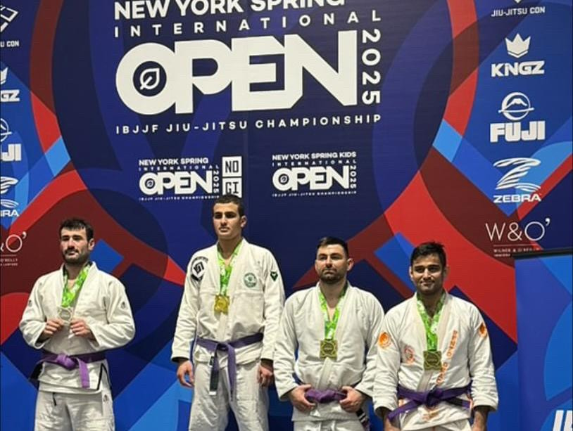 Quatre compétiteurs ceinture violette en kimono blanc sur le podium