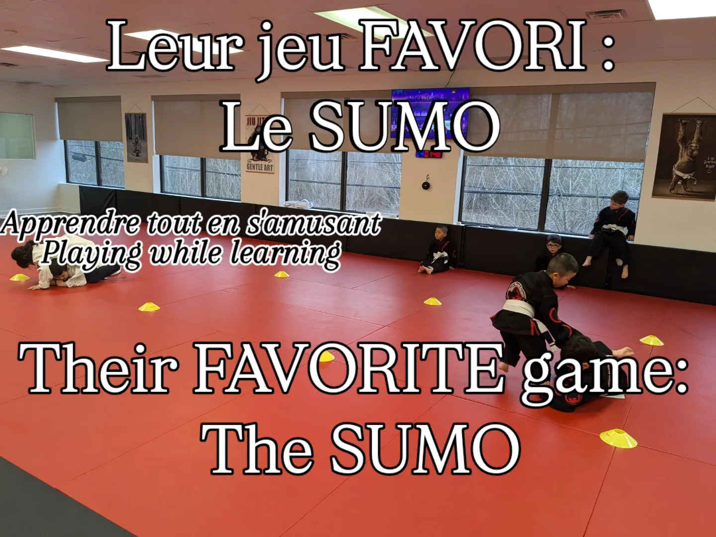 Young students in gis play sumo on red mats inside a ring of yellow cones