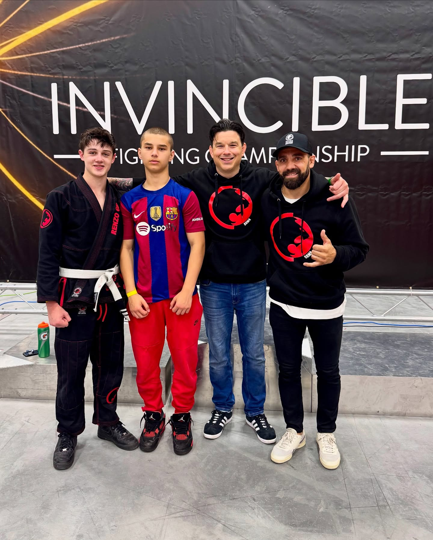 Dois adolescentes competidores e dois professores posam num torneio