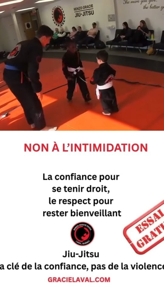 A young kids class on orange mats above an anti-bullying message in French