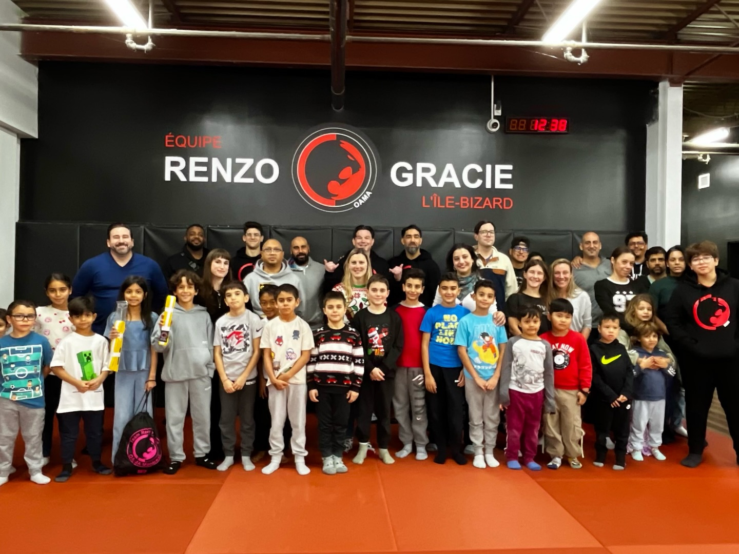 Children and adults in casual clothes pose together for a holiday group photo