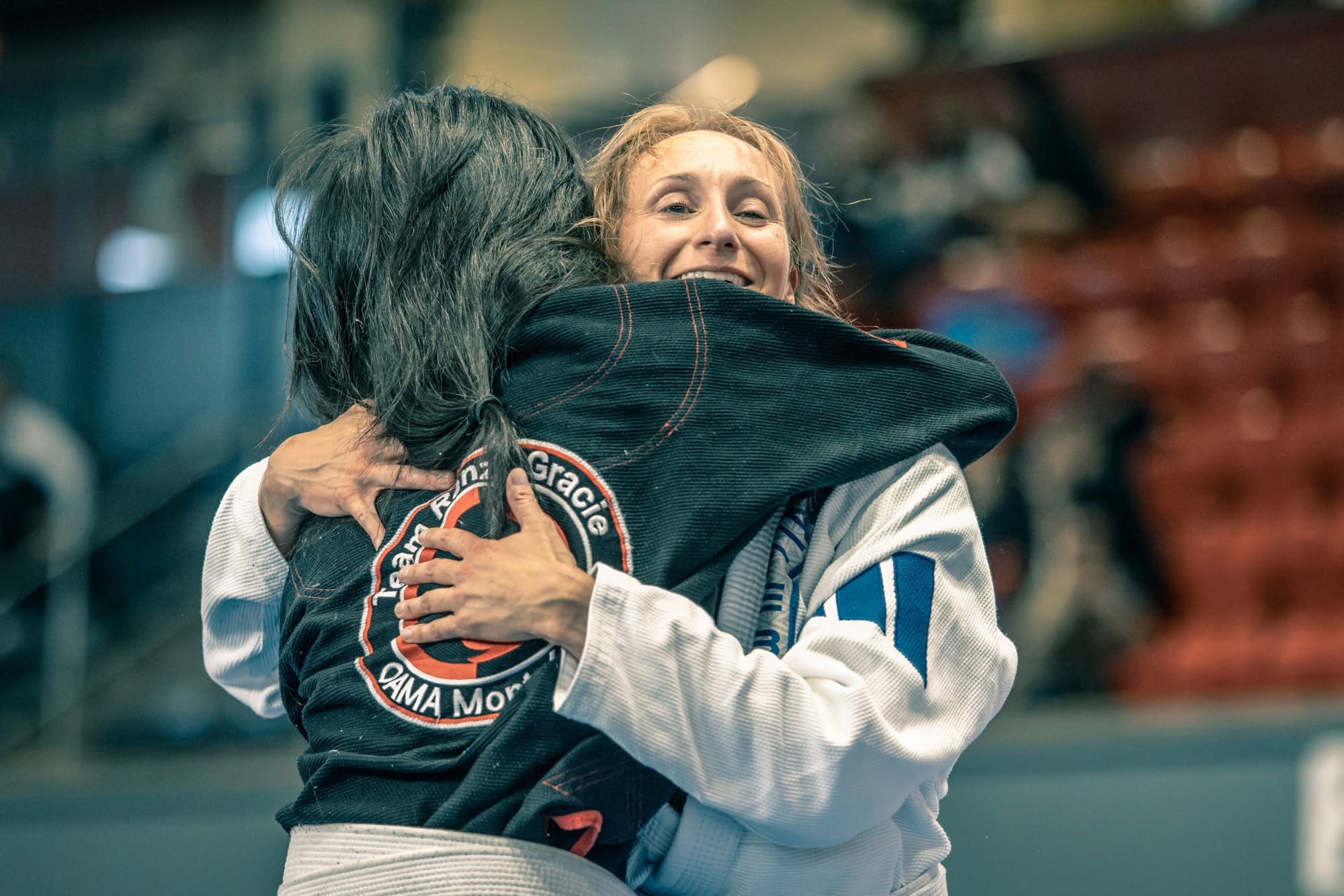 Duas mulheres se abraçam depois da luta no SAU Montreal Regional 2026, uma com o kimono Renzo Gracie