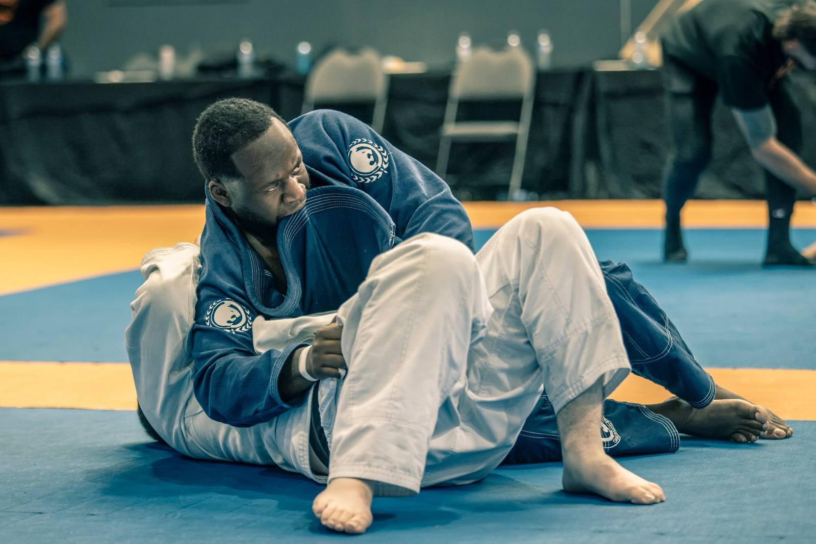 Élève adulte de jiu-jitsu travaillant depuis la garde à un tournoi de Montréal